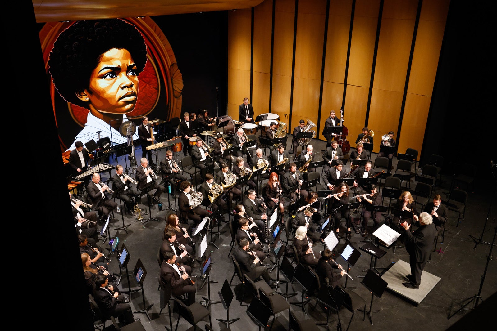 Symphony performing on the Rezanoor Stage with an image displayed on the digital wall behind them.