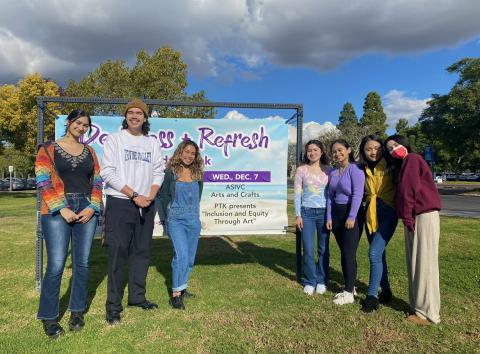 PTK Club posing in front of event banner 