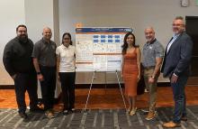 Student and IVC Administrators in front of project poster 