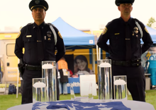 Officers standing before table and US flag